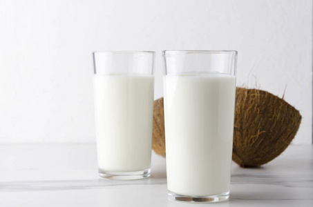 白色干净桌子上的两杯有机椰奶Kefir对白色