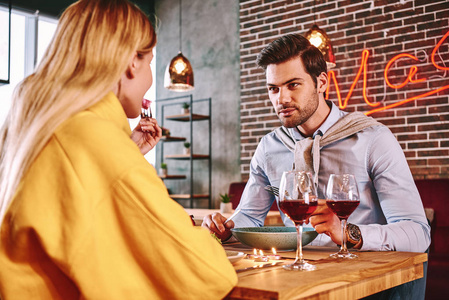 浪漫的晚餐穿蓝色衬衫的男人和女朋友吃饭和说话