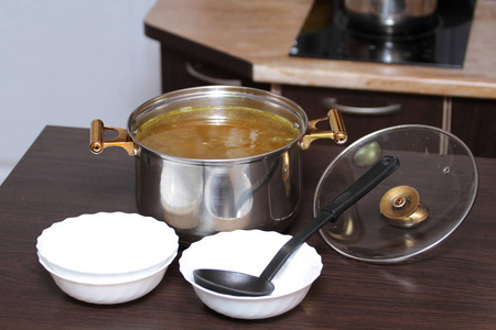 桌上放汤和盘子，把锅盖上
