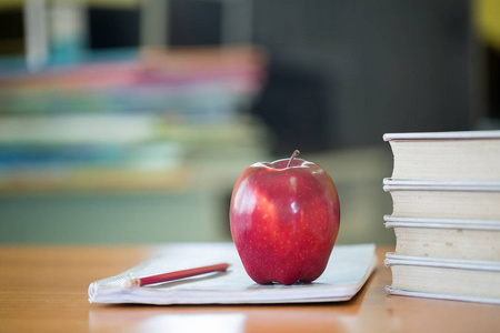 s desk with stack of books and apple, Educational concept.