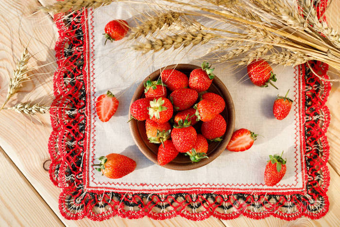 草莓在陶瓷碗的乡村背景与小麦耳朵. 关闭高分辨率产品. 收获概念