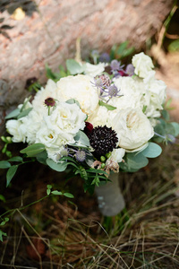 关闭小新娘花束白色牡丹玫瑰和绿色植物与缎带在木材背景户外复制空间。 婚礼概念