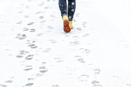 下雪走路冬天穿黄色皮靴走路.