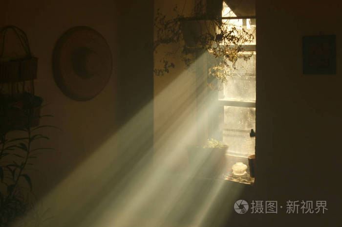 光线从一所旧乡村房子的窗户里照射出来。 昏暗的旧房子里的天光。