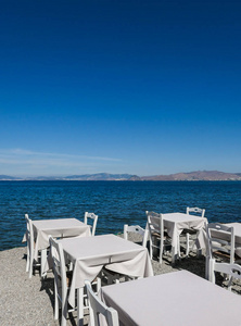 白色的餐厅桌在海滩上的夏季旅行，假期和夏季的概念.提供海景的完美午餐