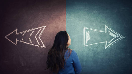 困惑的女人后视和分裂黑板与箭头走两种不同的方式，红色和蓝色的一面。 正确选择左右失败或成功。 困难的决定和怀疑的概念。