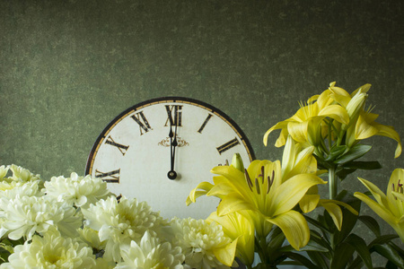 带有罗马数字的古董钟，菊花和百合花。 12小时