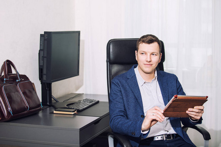 年轻的成年男性商人在他的办公桌上,上班时间办公室里有一台电脑照片