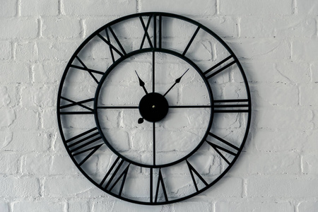 老式时钟与罗马数字。 公寓内白色砖墙上的墙钟面刻度图