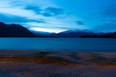 夜光穿过瓦纳卡湖，在蓝调的天空下雪山