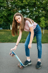 女孩少女 911, 骑滑板。在夏天在城市穿着休闲牛仔裤和运动鞋
