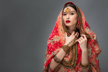 迷人的印度妇女，摆着传统的纱丽和灰色的配饰