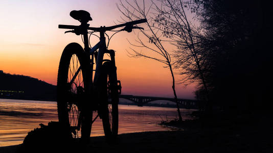 在河边日落时骑自行车