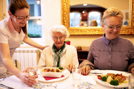 有爱心的护士为晚餐提供膳食，并在养老院接待人们