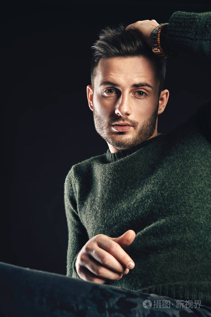 一位英俊的时尚男士的肖像,他的头发摆在黑暗的背景上