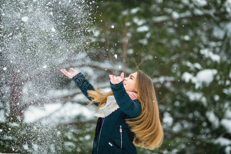 美丽的女孩在一个惊人的冬天玩雪。
