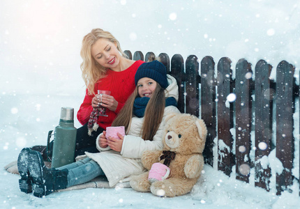 年轻的家庭享受在多雪的冬天在自然中散步