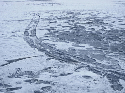 冬天的冰冻池塘表面有许多各种机械和人类的指纹