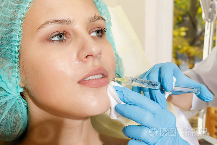 医生美容师为病人的美丽在前额打针美容学中的美容注射美的概念