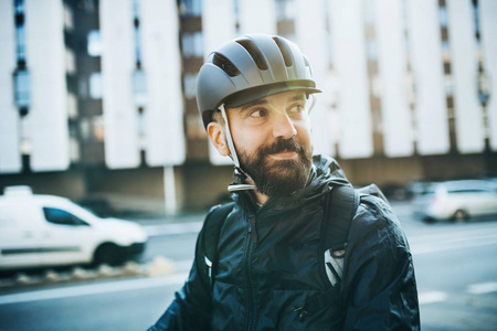 男性信使与自行车头盔送包裹在城市