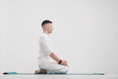 男子黑发, 胡子在白色的背景上, 白色的背景, 双手交叉在他的胸部。冥想和祈祷, 瑜伽