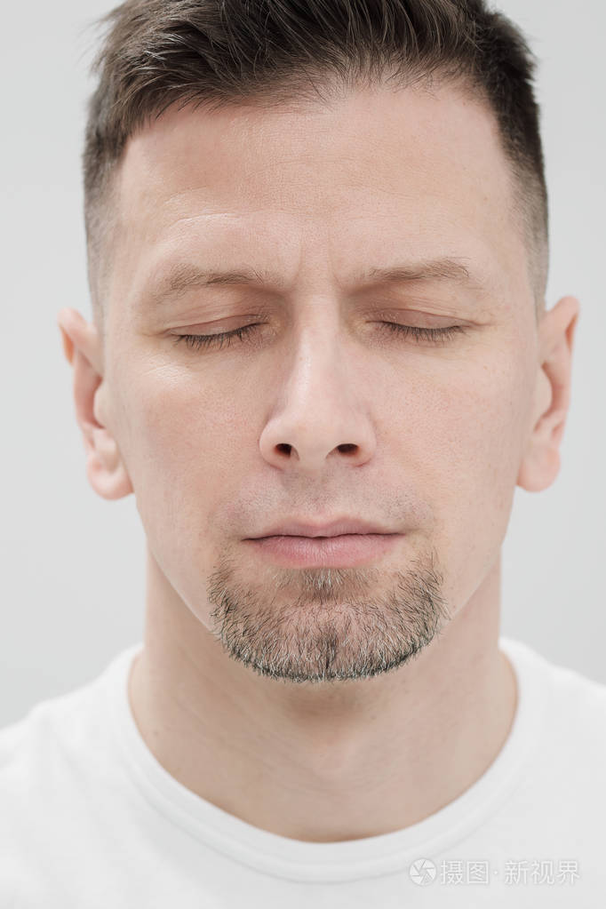 一个穿着白色衣服的留胡子的黑发男子的脸眼睛闭上了