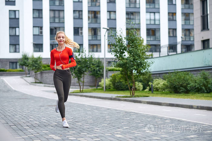 年轻的女跑步者在城市街道慢跑.