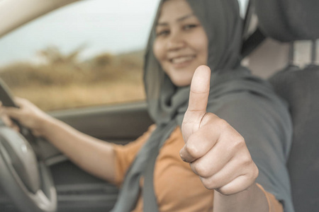 亚洲穆斯林女士的肖像，微笑，同时驾驶她的汽车生活方式，享受乐趣，休闲度假，旅行，乘车分享概念