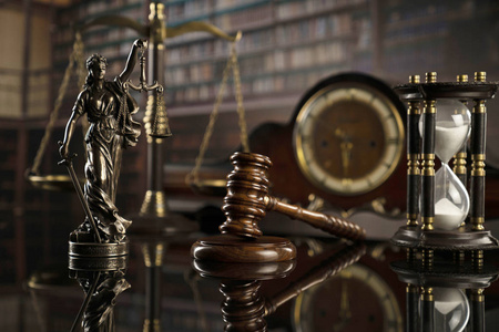 法律概念。 法官雕像的木槌，司法规模和法律书籍。 法庭图书馆。