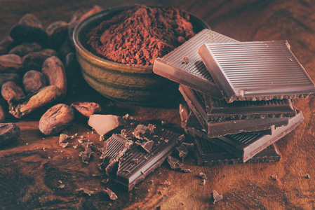 木桌上碎的黑巧克力可可粉和咖啡豆
