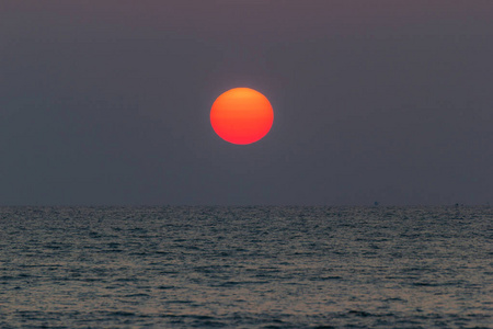 太阳在海上升起，从海上日出发出橙色的光，美丽的是日出的光