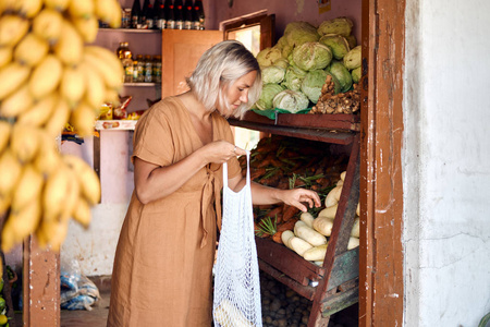 妇女购买新鲜水果在异国情调的当地市场
