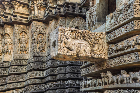 印度卡纳塔克邦Halebidu2013年11月2日希瓦霍伊萨莱斯瓦拉神庙。 一堆同样主题的雕像和更大的丝带在寺庙建筑的一侧。 