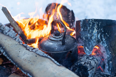 水壶在篝火上沸腾。 生火做饭