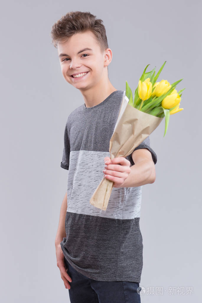 节日爱幸福人们观念快乐的孩子庆祝情人节带着花的少年男孩灰色背景上