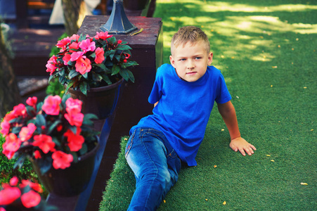 一个男孩坐在有花的露台上的肖像