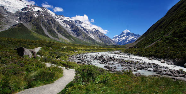 美丽的自然景观。 背景中的岩石河流和雪山。 步行钩谷轨道山库克新西兰。 在大自然中徒步旅行和散步。