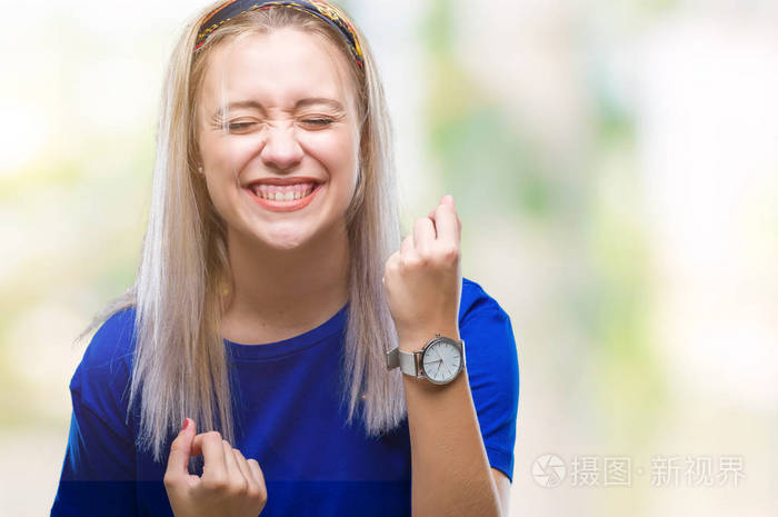 年轻的金发女子在孤立的背景下,非常高兴和兴奋地做着胜利者的手势