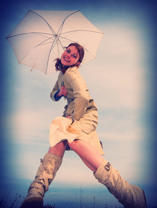 一个拿着伞顶着天空的女孩