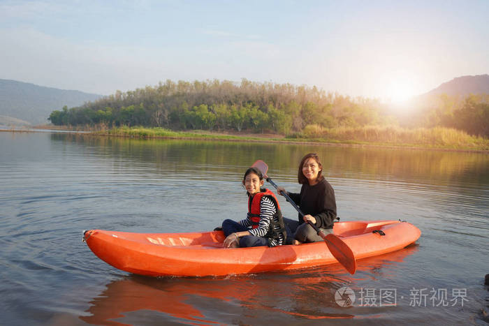 母亲和女儿在平静的水面上划船