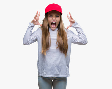 年轻漂亮的女孩戴着红色帽子，独自庆祝疯狂和疯狂的成功，手臂抬起和闭上的眼睛尖叫兴奋。 赢家概念