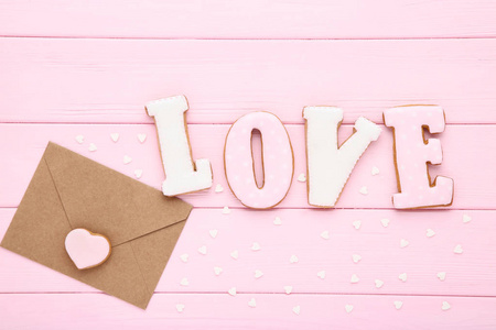 用自制的饼干和心形的果盘和粉色木桌上的信封表达爱