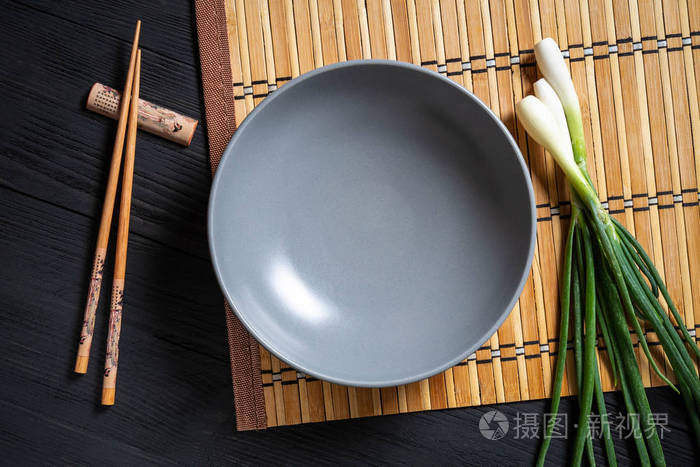 空碗泡面用筷子夹在黑色木制背景上有一个复制空间的地方