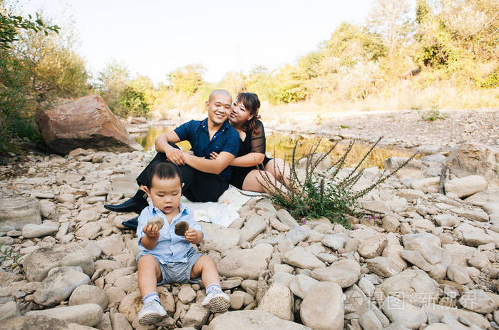 幸福的韩国家庭在河边散步在山上爸爸妈妈和儿子亚洲人笑着拥抱