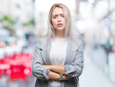 年轻的金发商务女性穿着夹克，在孤立的背景怀疑和紧张的不赞成的表情在脸上交叉的手臂。 消极的人。