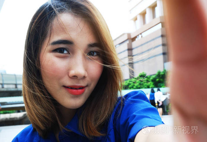 特写女人微笑自拍和旅行在城市.