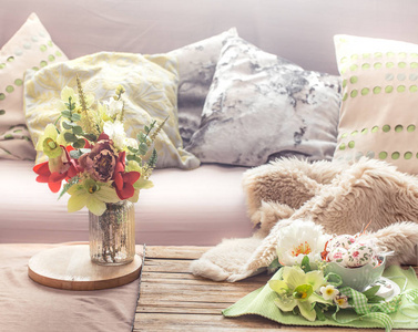 客厅里温馨舒适的春天室内，有花瓶和鲜花的家庭舒适概念