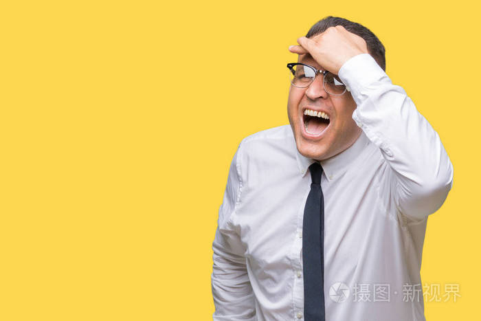 男人戴着眼镜,在孤立的背景下,非常高兴和微笑,用手捂住头看着远方