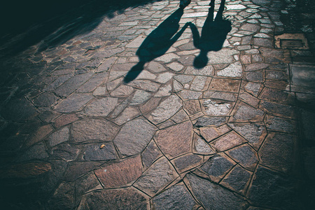 城市里两个人手拉手的剪影.照片