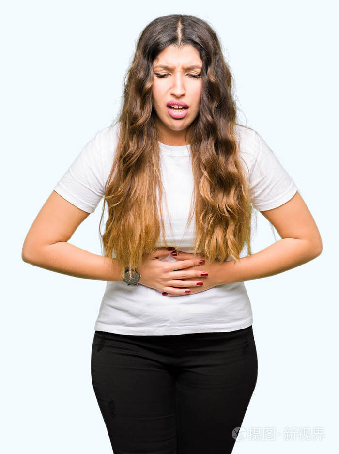 年轻漂亮的女人穿着休闲的白色t恤手放在肚子上因为消化不良痛苦的